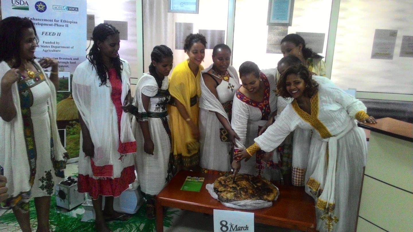 Women cutting food to celebrate.